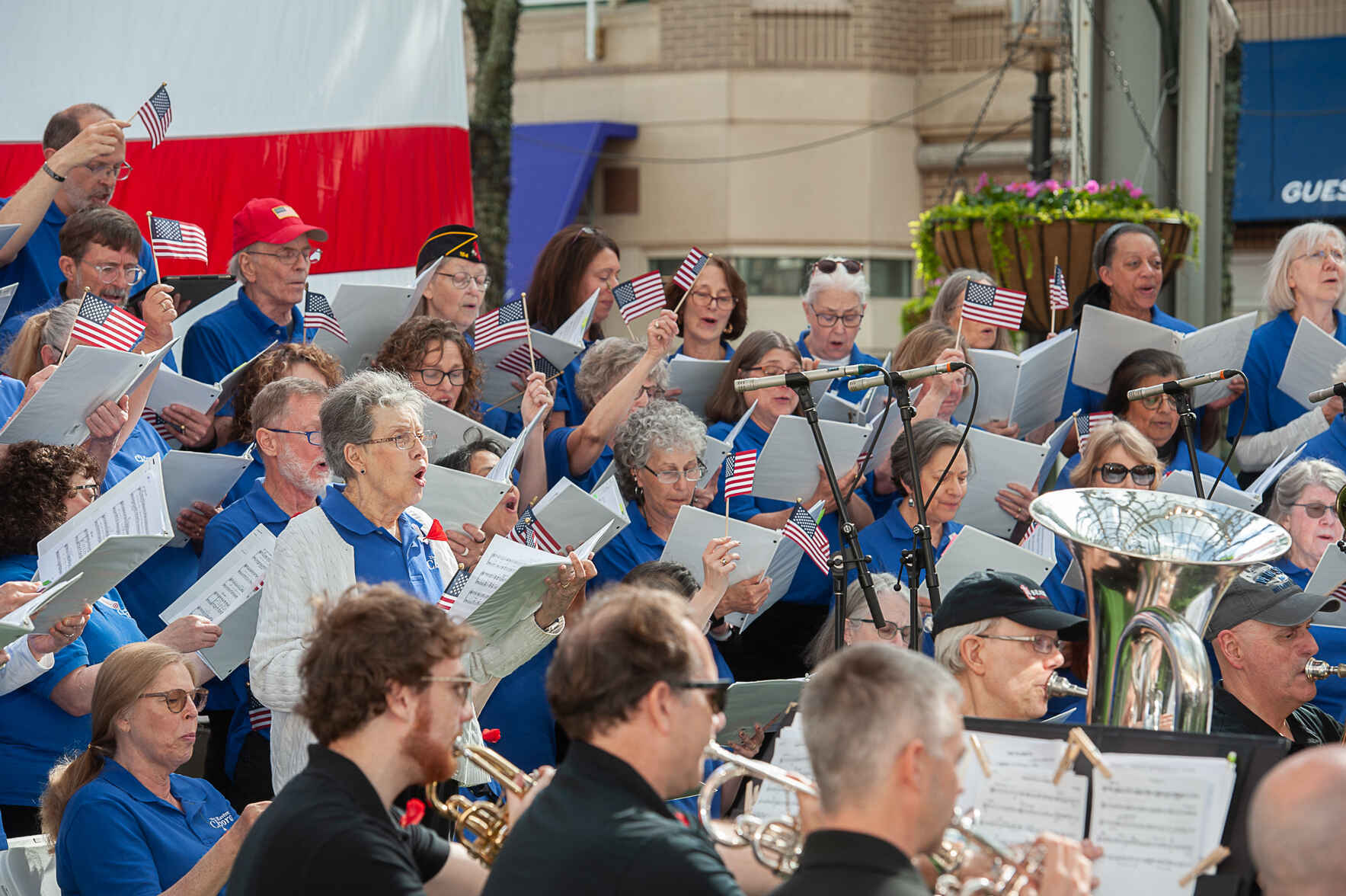 an orchestra plays instruments with small american flags on their music stands