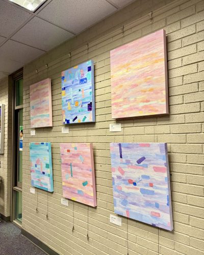 Colorful abstract paintings with blue, pink, and purple tones attached to the wall of the Office of Braddock Supervisor Sizemore Heizer as part of the "Art of Happiness" exhibit by Catalina Novac.
